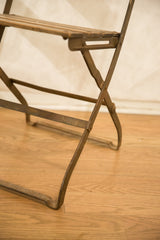 Vintage French cafe chair's metal folding frame with rich, aged patina.