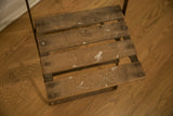 Close-up of vintage cafe chair's wood seat slats, showing visible wear and paint.