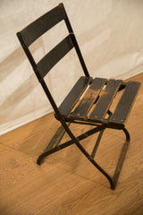 Vintage French Cafe Chair's dark metal frame and aged black wood backrest slats.