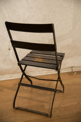 Folding metal frame and distressed wood seat slats of the vintage French cafe chair.