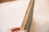 Vintage painting's canvas edge, showing staple fasteners and fabric texture.