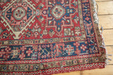 Corner of a Vintage Karaja rug, highlighting geometric pinwheel motifs and tattered navy blue selvage.