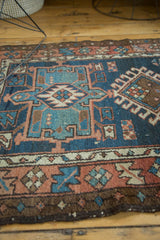 Antique Karaja rug's geometric patterns and border with time-softened denim blue and terra cotta.