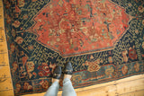 Armenian Seichor Kuba rug showcasing geometric navy border and blush field with stylized florals.