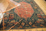 Geometric navy blue field and rose motif border of an antique Caucasian Seichor Kuba rug.