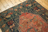 Antique Seichor Kuba rug with blush medallion, navy field, and ornate green border.