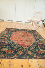 Texture of antique Seichor Kuba, dark navy field with meandering hook and vines, blush medallion.