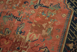 Antique Seichor Kuba rug's madder field with meandering hooks, stylized roses, and a dark navy border.