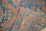Hand-knotted foundation and worn pile detail of an antique Heriz rug, tattered ends visible.