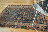 Geometric patterns and bold borders on antique Caucasian rug, navy, madder red, gold, with even wear.