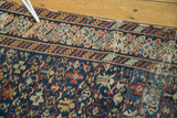 Antique Caucasian rug: intricate border, navy, madder red, gold motifs, exhibiting wear.