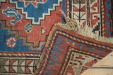 Tattered plain weave fringe and intact side selvage of a vintage Caucasian rug.