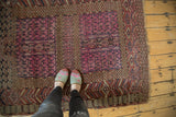 Antique Turkmen rug showing hot pink geometric panels, stylized animal figures, and crab borders.