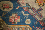 Intricate blue and red geometric, bird motifs, and wave border on an antique Soumac rug.