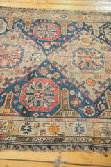Intricate wave design border in blue and beige, light tatter on Soumac fringe.