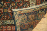 Antique Caucasian runner's tightly woven reverse, fringe, and chocolate, red, blue geometric motifs.