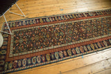 Antique Kuba runner with repeating boteh border, madder red and navy, showing even pile wear.