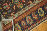Antique Kuba Caucasian runner detail: navy boteh border, ivory geometric guard, madder red, saffron accents.