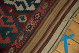 Corner view of handwoven vintage Shahsavan Kilim with geometric pattern, striped reverse, and fringed end.