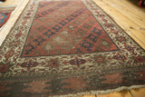Worn geometric starburst border, with tattered plain weave at antique Belouch rug end.