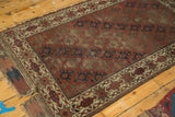 Antique Belouch rug: striated medallions on chestnut field with aged geometric starburst border.