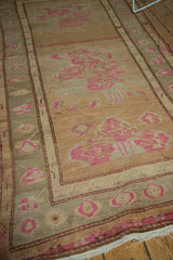 Vintage Oushak rug corner showing blush rose bouquet designs on camel and olive.