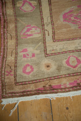 Hand-knotted Oushak rug detail showing blush pink patterns, abrashed camel field, and fringe.