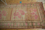 Abrashed camel sand beige vintage Oushak rug field with blush pink floral bouquets.
