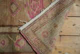 Hand-knotted reverse of the vintage Oushak rug, revealing beige pile with subtle pink motifs.