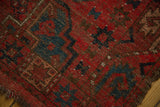 Vintage Beshir rug's cherry red and navy blue gul motif, showcasing soft pile and worn edge.