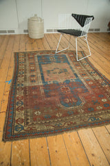 Antique Prayer Kazak rug: square medallion, madder red geometric field, running T border.
