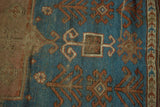 Antique Kazak rug detail: sky blue field with germinating plant motifs and running T border.
