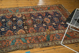 Antique Kurdish runner displaying a terracotta border, teal patterns, and visible material loss.