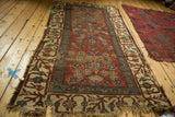Antique Kurdish Bijar rug featuring unique Herati motif on a madder red field with heavy edge tatter.