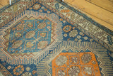 Patina on geometric field and serrated leaf border of antique Caucasian rug, in blue and orange.