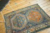 Asymmetric color fills and geometric patterns on this antique Caucasian rug, with time-softened tones.