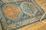 Antique Caucasian rug's serrated leaf border and visible light tatter on side.