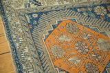Serrated leaf border and geometric medallion detail of antique Caucasian rug with navy, tangerine, beige palette. Worn.