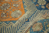 Geometric orange and blue patterns, serrated border, and even wear on antique Caucasian rug.