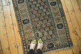 Antique Caucasian rug detail: staggered floral field, serrated border, teal navy, orange, foundation showing.