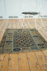 Antique Caucasian rug detail: staggered floral pattern, serrated border, teal navy and tangerine.