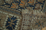 Detail of an antique Caucasian rug's tattered fringe, visible foundation, and staggered floral pattern.