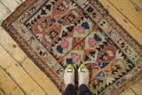Antique Caucasian rug's serrated geometric patterns in tangerine, navy, blush, and charcoal colors.