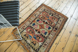 Rectilinear serrated design of the Caucasian rug with tangerine, navy, blush, and beige.