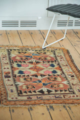 Antique Caucasian rug corner, rectilinear patterns in tangerine, navy, blush, with light fringe tatter.