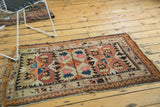 Rectilinear geometric patterns and tattered fringed corner of an antique Caucasian rug.