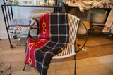 Eco Plaid Horse Bit Throw with red and gold chain motif and black plaid pattern.