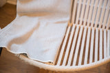 Textured gray herringbone weave of the eco-friendly blanket, highlighting its folded edge.