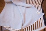 Gray herringbone throw blanket showcasing its woven texture and 'in Green' tag.