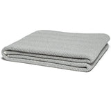 Gray herringbone throw blanket, neatly folded to reveal its visible woven texture.